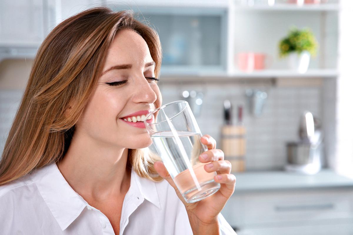 young-woman-drinking-clean-water-glass-alkaline-water-benefits-ss.jpg